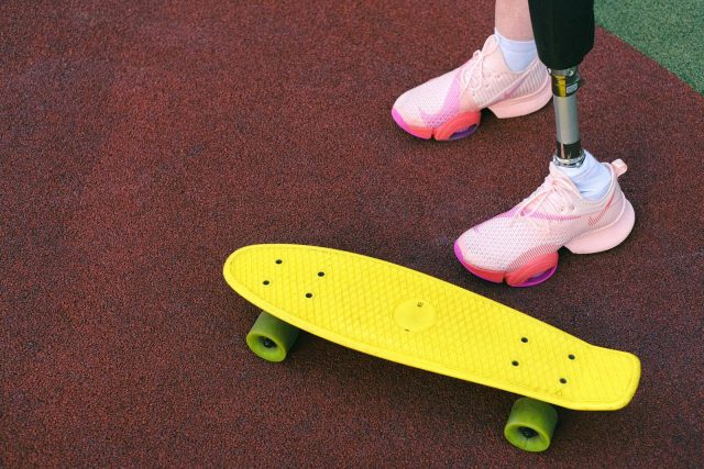 A vibrant image showcasing adaptive skateboarding with a prosthetic leg on colorful ground.